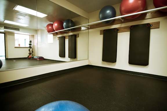 A gym with a blue exercise ball in the foreground.