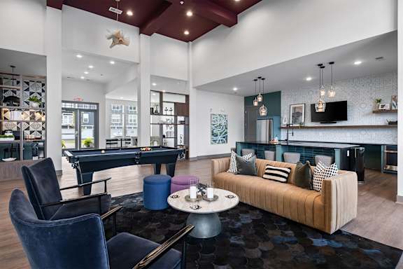 A modern living room with a pool table and a couch.
