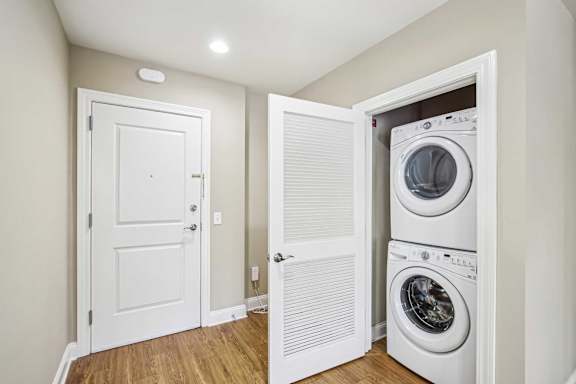 A white door is open to a laundry room with a washer and dryer.