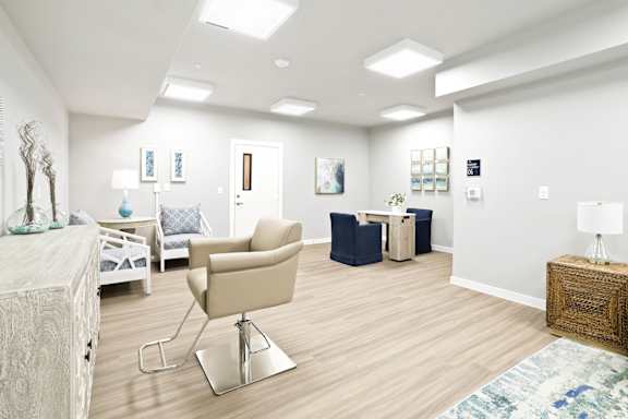 A living room with a beige chair and a white couch.