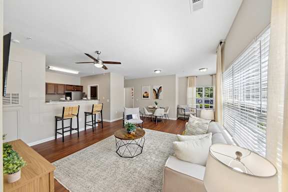 A living room with a white couch and a ceiling fan.
