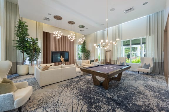 a large living room with a pool table in the middle