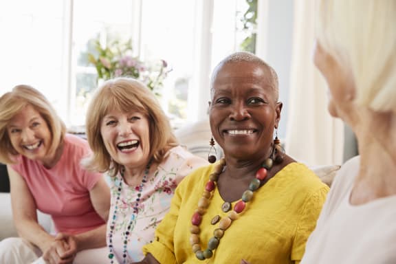 a group of women sitting on a couch laughing