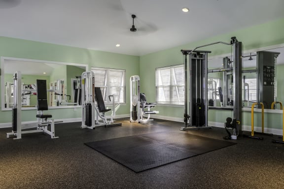a large fitness room with exercise equipment and windows