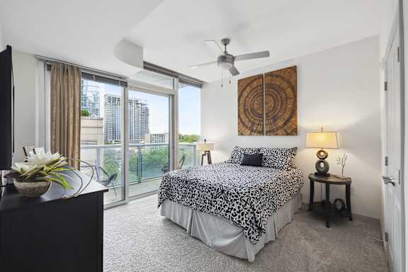 A bedroom with a large bed and a ceiling fan.