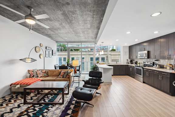 A modern living room with a couch, chairs, and a rug.