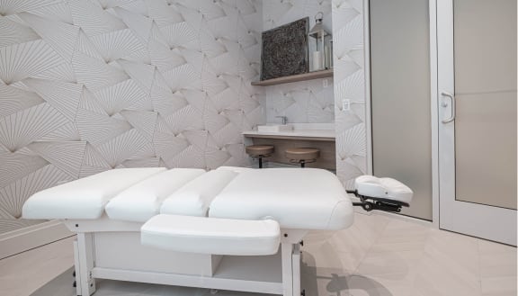 a spa room with four massage tables in front of a wall with a geometric wallpaper at Altis Grand Lake Willis, Orlando, 32821