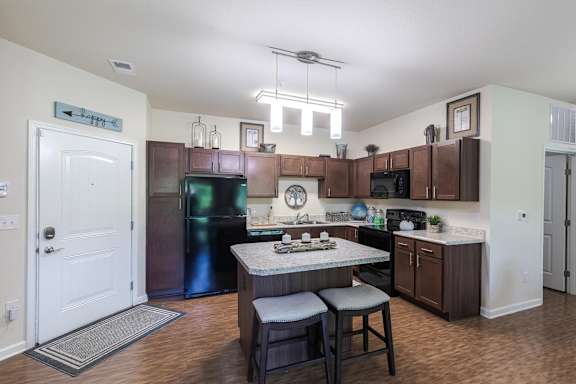 A kitchen with a table and chairs in the middle of it.