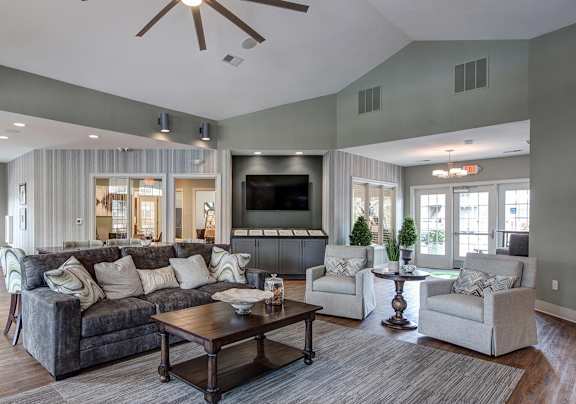 A living room with a grey couch, a wooden coffee table, and a flat screen TV.