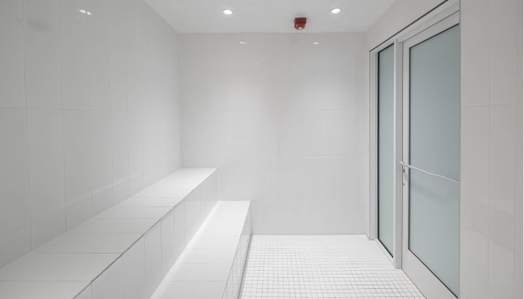 an empty room with white tiles and a glass door at Altis Grand Lake Willis, Orlando, FL