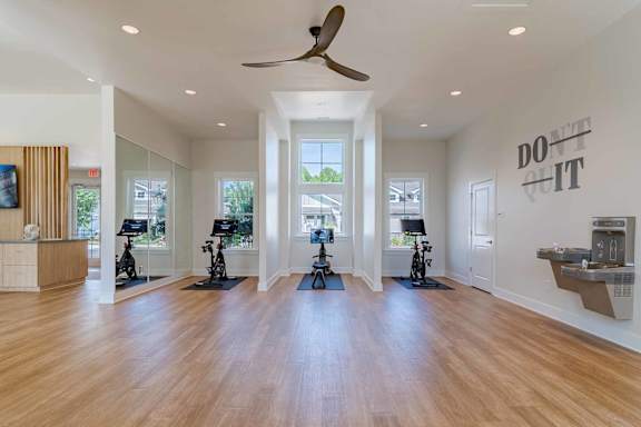 A spacious room with a wooden floor and a ceiling fan.