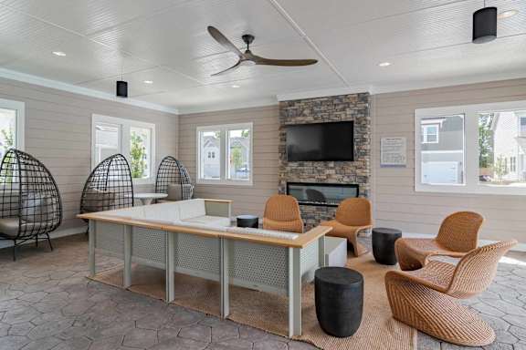A room with a stone fireplace and a television above it.