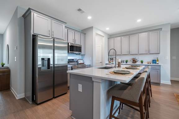 A modern kitchen with a large island and stainless steel appliances.