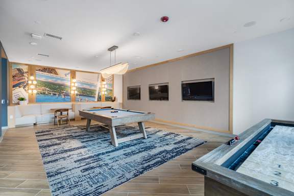 A billiard table is in the middle of a room with a pool table.
