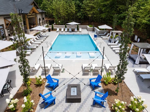 a resort style pool with blue chairs and chairs around it