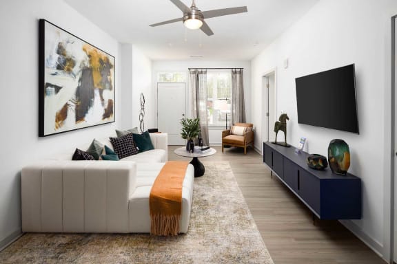a living room with a white couch and a ceiling fan