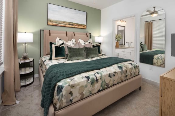 a bedroom with a large bed and a mirror