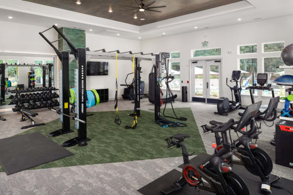 a gym with weights and other exercise equipment in a building with glass doors