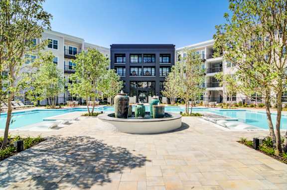 A large building with a pool in front of it.