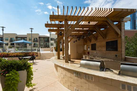 A wooden pergola is in front of a building.