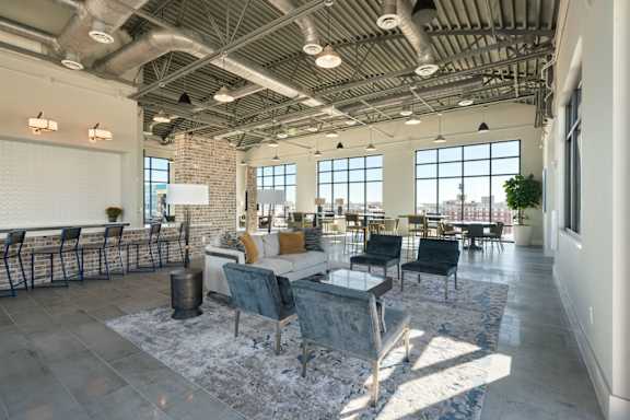 A large room with a lot of furniture and a brick wall.