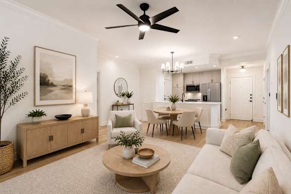 A living room with a white couch and a wooden coffee table.