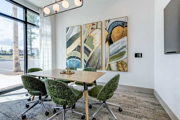 A conference room with a long table and chairs.