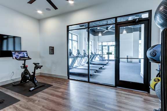 A room with a treadmill and a television.