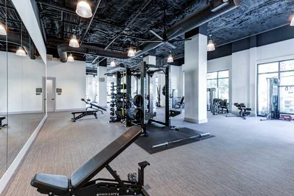 A gym with a variety of equipment including a weight bench.