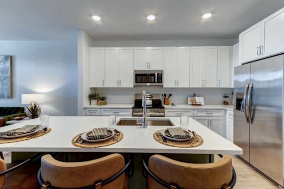 A modern kitchen with a large island and stainless steel appliances.