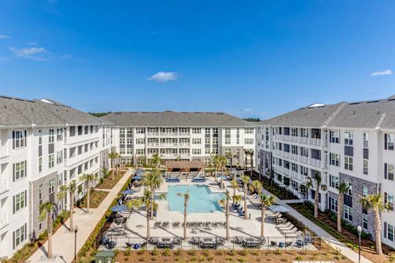 A large white building with a pool in the middle of it.