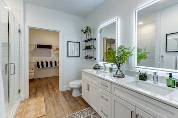 A bathroom with a toilet, sink, and mirror.