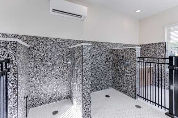 A bathroom with a black and white tiled shower.