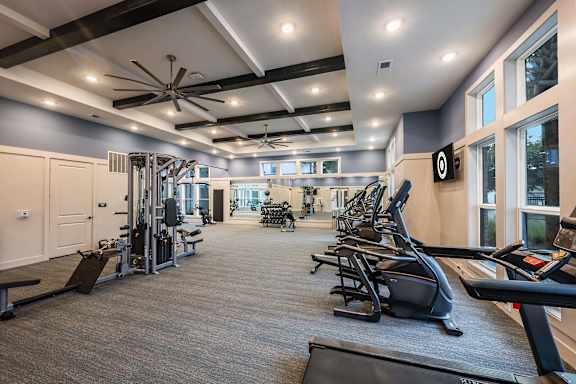 A spacious gym with a variety of equipment including treadmills, weights, and exercise machines.