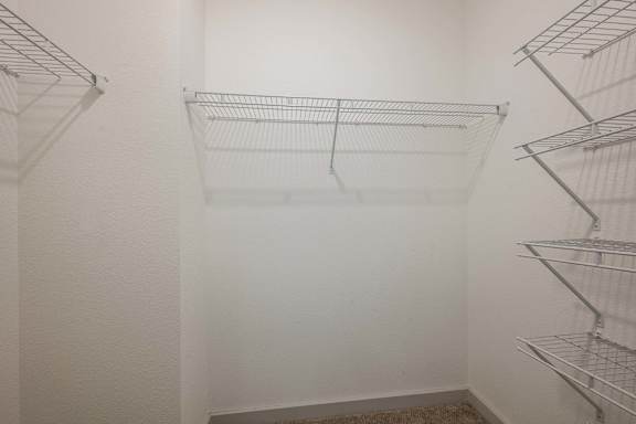 Empty shelves in a white pantry.