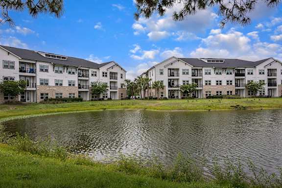 A large body of water is in front of apartment buildings.