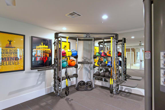 a fitness room with weights and a tv on the wall