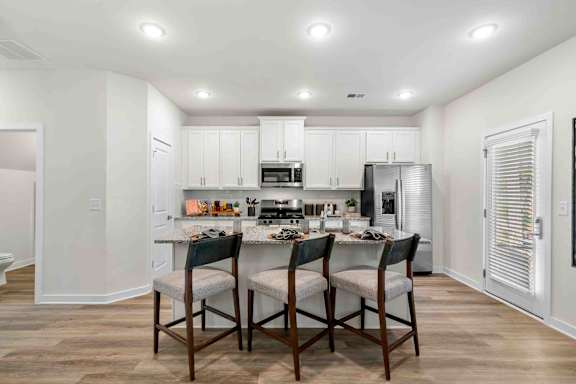 A kitchen with a table and chairs in the middle of the room.