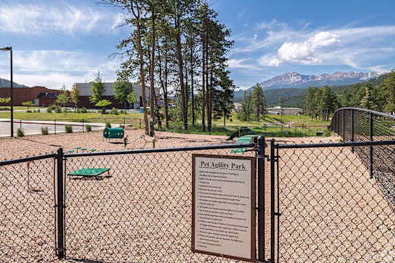 A sign in front of a fence reads "Pet Agility Park".
