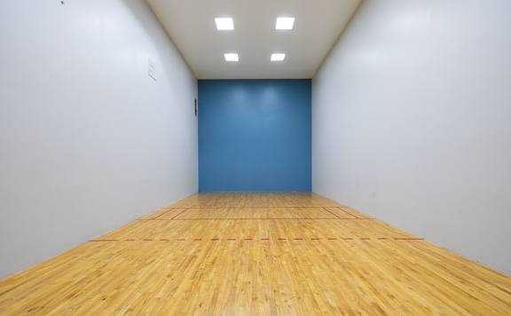 A room with wooden flooring and a blue wall.