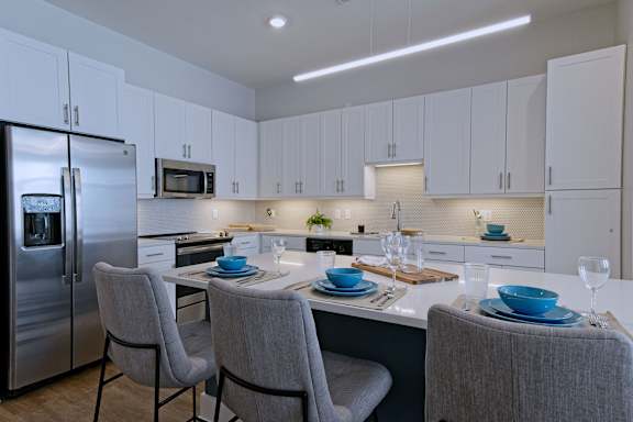 A modern kitchen with a table set for two.