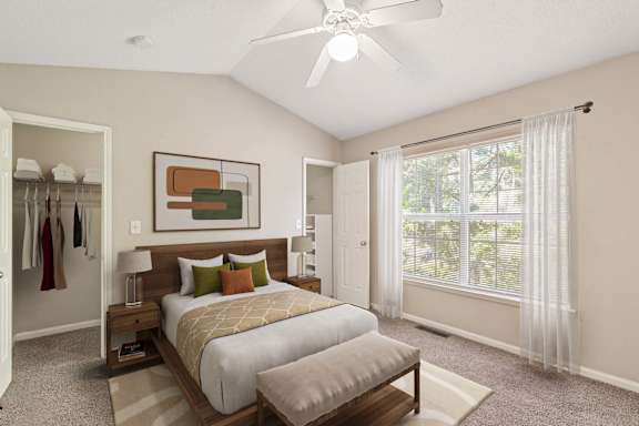 A bedroom with a large bed and a ceiling fan.
