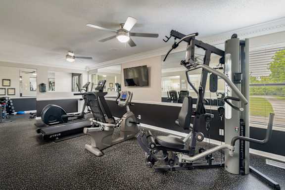 A home gym with a treadmill, elliptical trainer and a stationary bike.