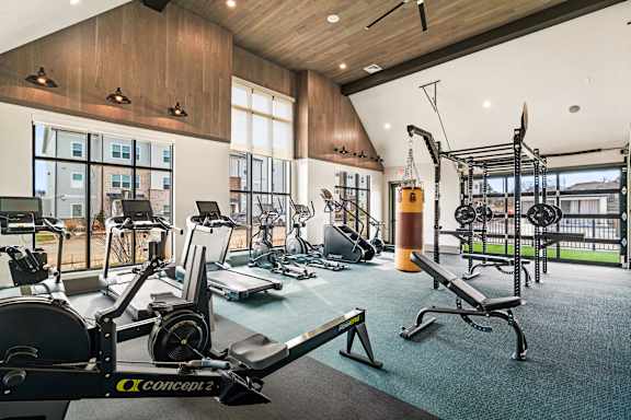 A gym with a variety of equipment including a rowing machine.