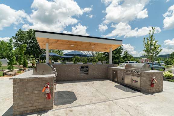 A covered outdoor area with a brick wall and a fire extinguisher.
