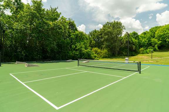 A tennis court surrounded by trees.