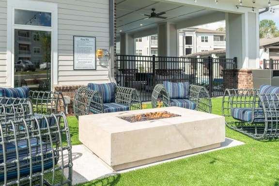 the outdoor patio has a fire pit and chairs around it