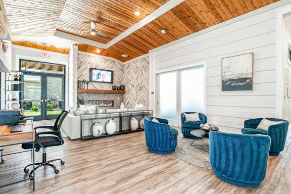 A room with a wooden ceiling and a fireplace with a TV above it.