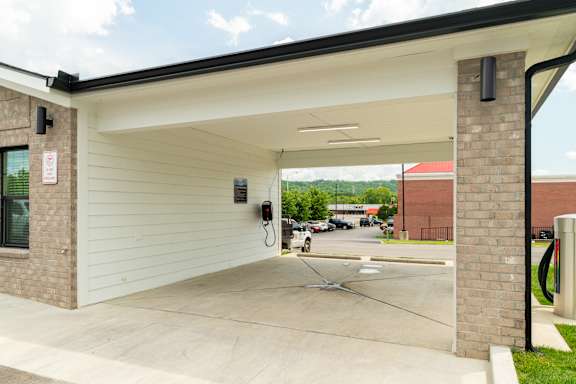 A parking garage with a brick pillar and a white wall.
