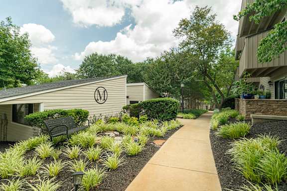 A pathway leads to a building with a logo on the side.
